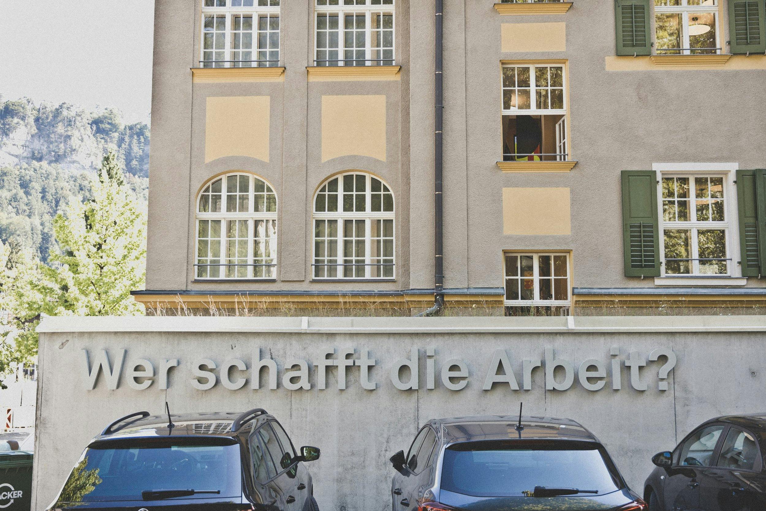 Schaffarei Branding: Betonschriftzug „Wer schafft die Arbeit?“ auf Fassade © Patricia Keckeis